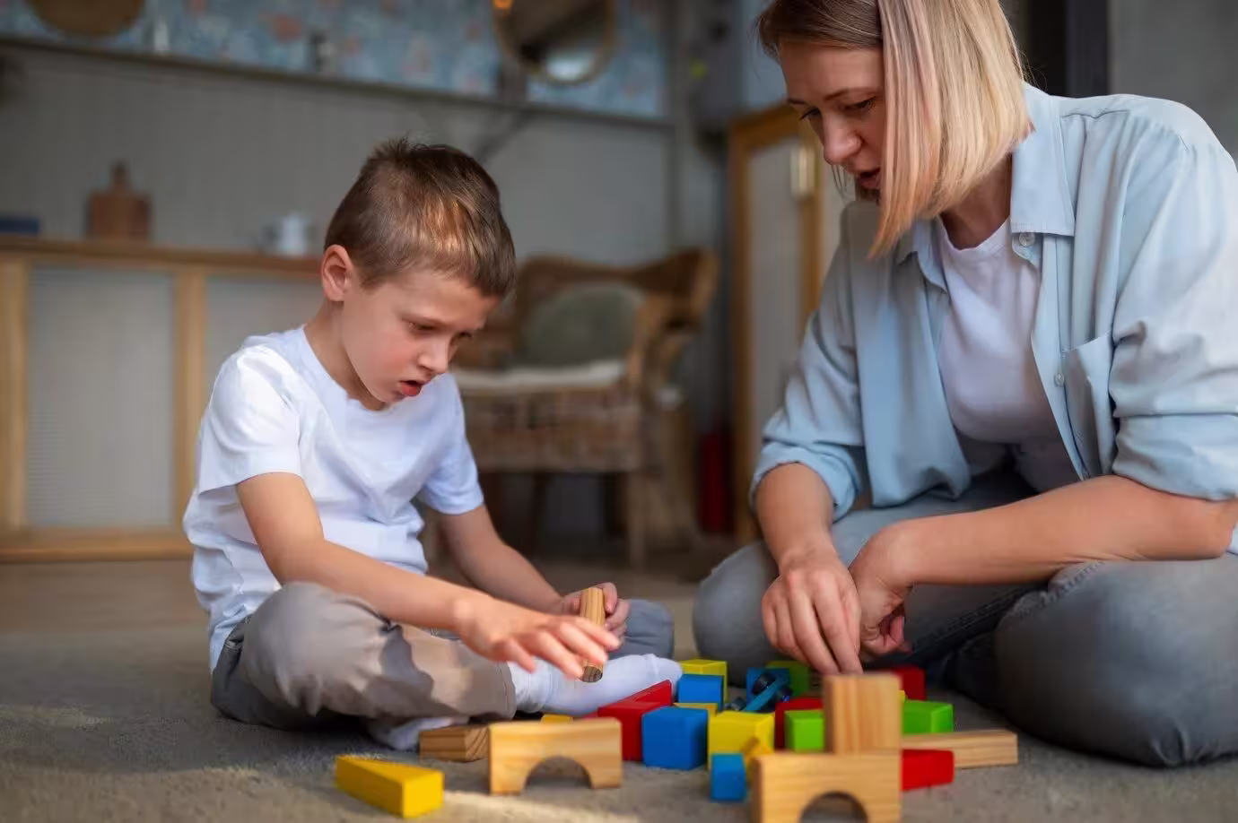 mother-playing-with-her-autistic-son-using-toys_23-2150266561