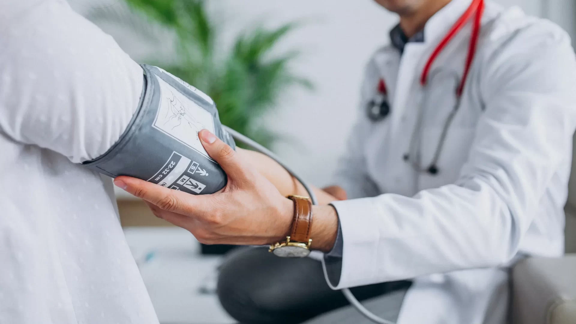 young-male-psysician-with-patient-measuring-blood-pressure